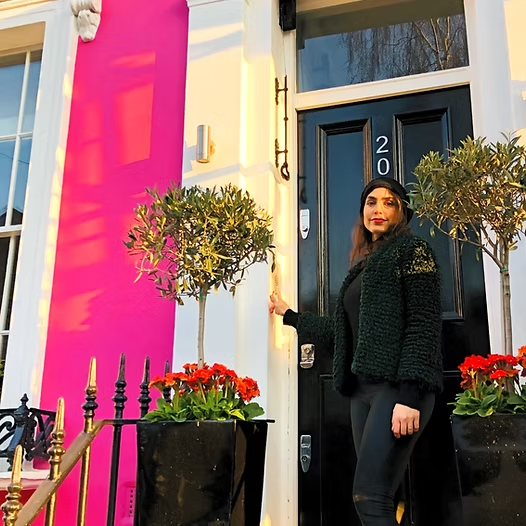 Sabina D'Ercole at the entrance of a colourful townhouse